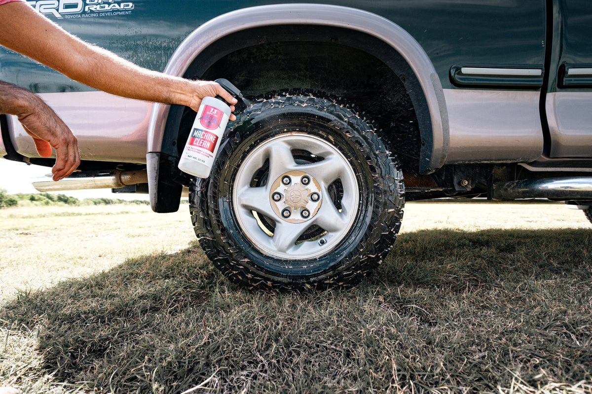 Step 1 pre-wash: spraying Machine Clean on a muddy truck tire